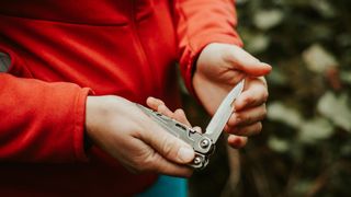 A person holding a multi-tool knife