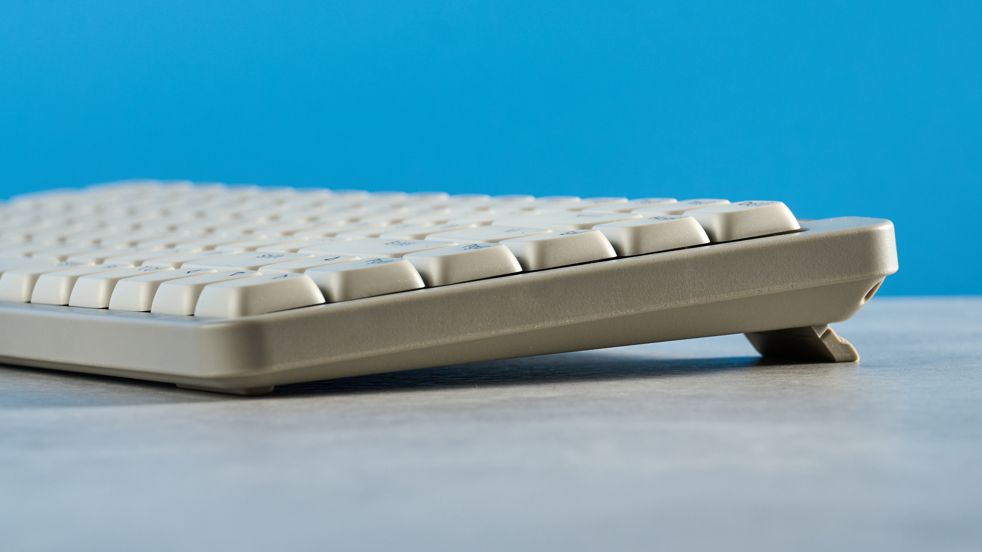 The Lofree Flow Lite84 on a stone surface against a blue background