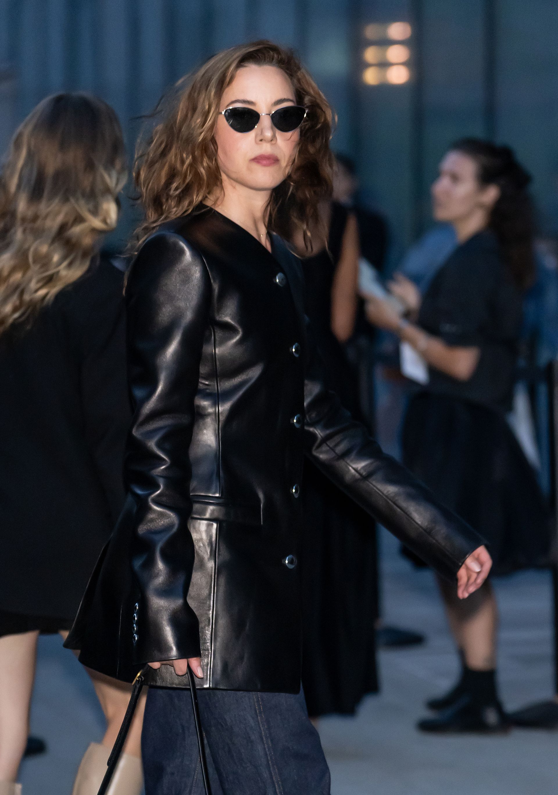 Photo of Aubrey Plaza wearing black leather collarless jacket.
