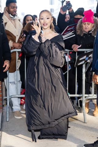 A photo of Ariana Grande sporting a black Norma Kamali sleeping bag coat in New York City.