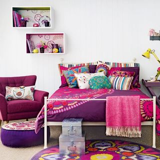 bedroom with multicoloured bed and arm chair