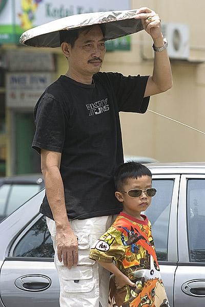 Like father like son: Dad and son looking cool as they watch the 2010 Tour de Langkawi go by.
