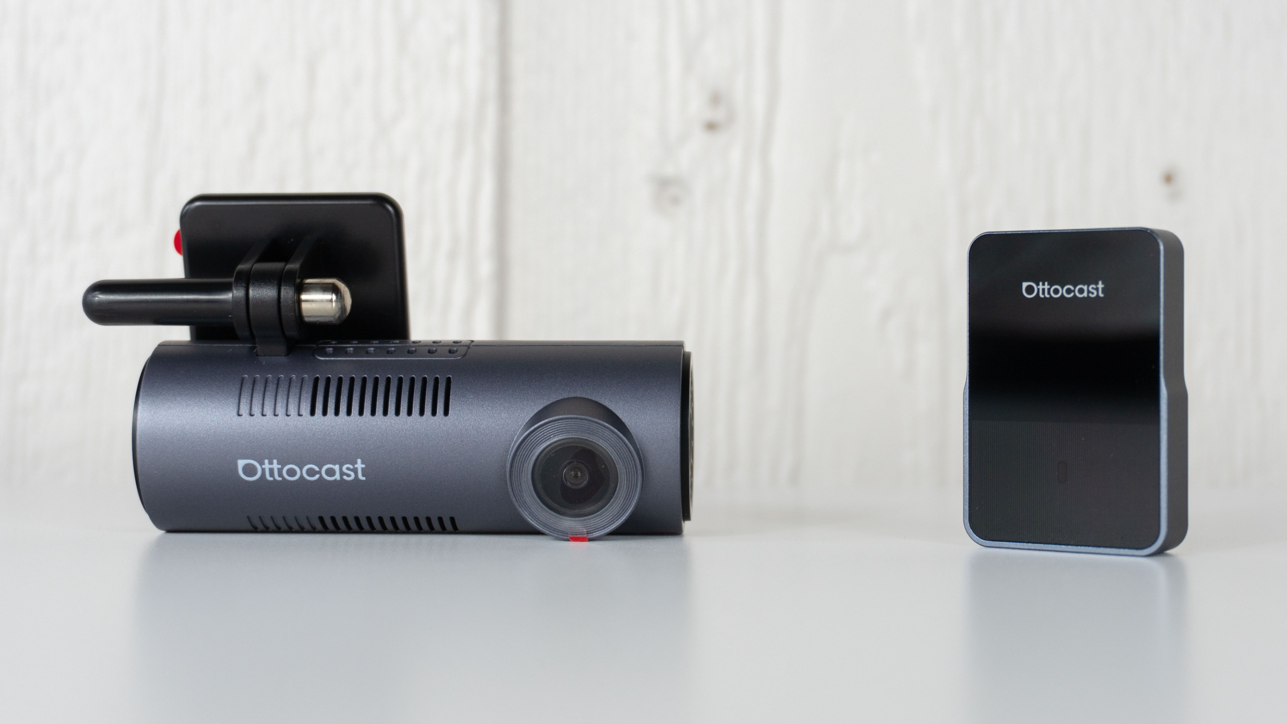 The Ottocast OttoSafe Cam's dashcam and wireless adapter next to each other on a table