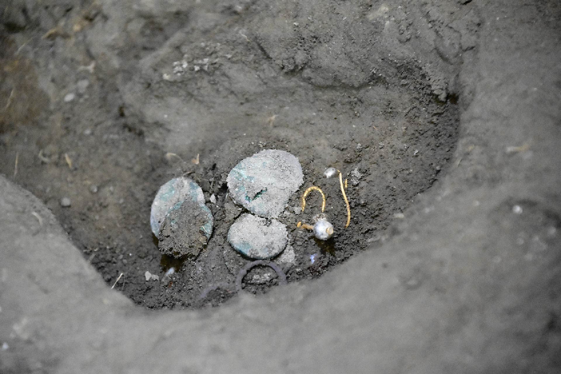 Treasures found near the woman skeleton consisting of coins and earrings