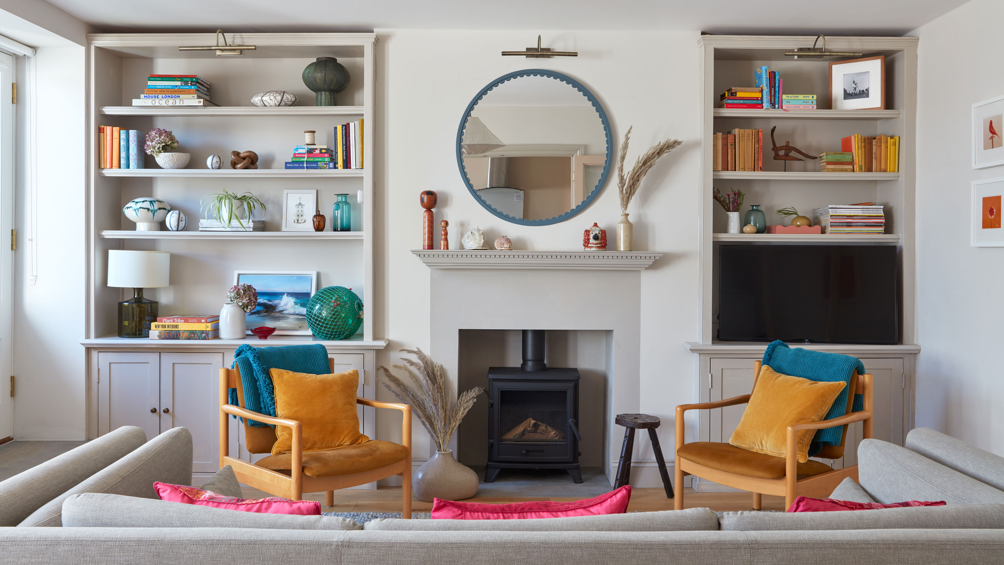 White and grey living room with blue mirror and yellow chairs