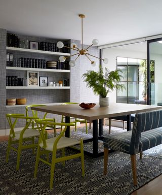 grey living room with textured wallpaper and lime green wishbone chairs