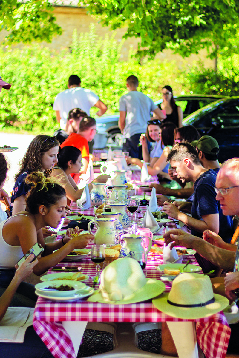 People sitting down at a long table for lunch