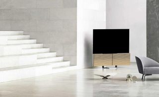 Large TV in a white room with stone walls and staircase