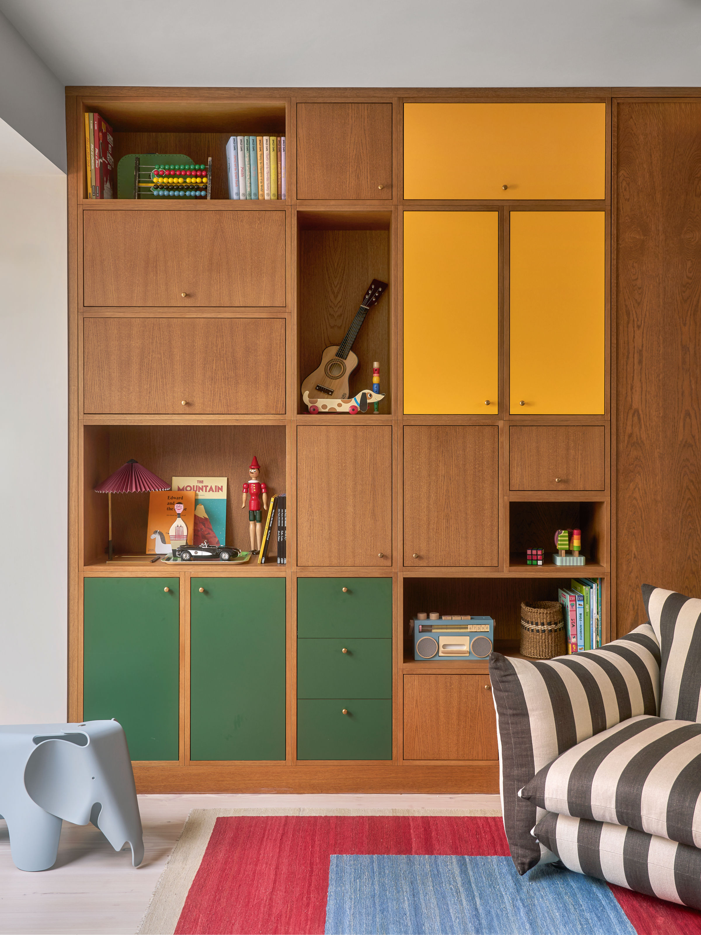 Wall of wooden joinery with handful of doors in yellow and green