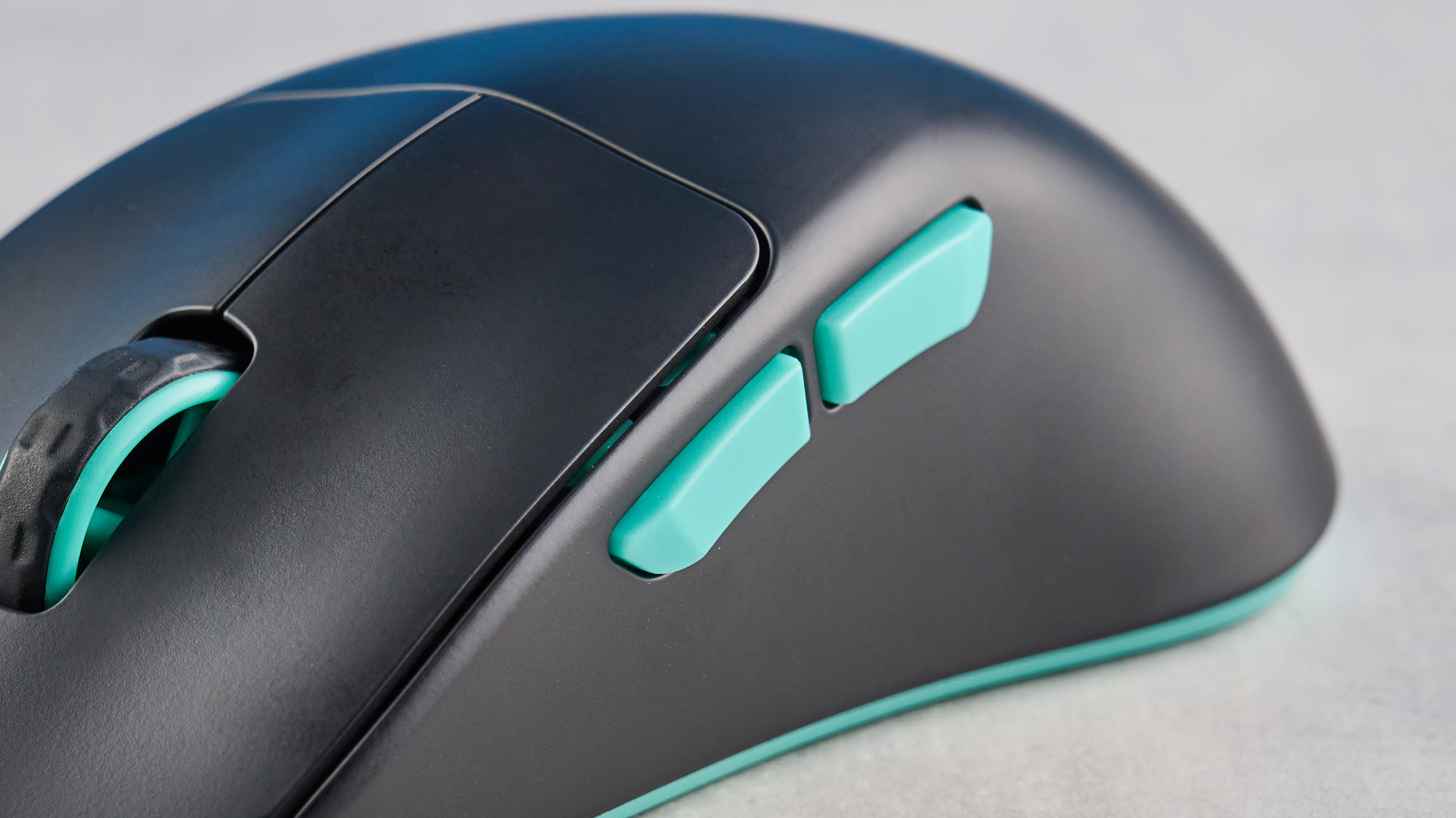 A black and teal Cherry XTRFY M64 Wireless gaming mouse