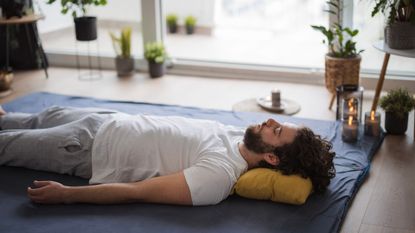 A man led on the floor trying to locate his pelvic floor muscles