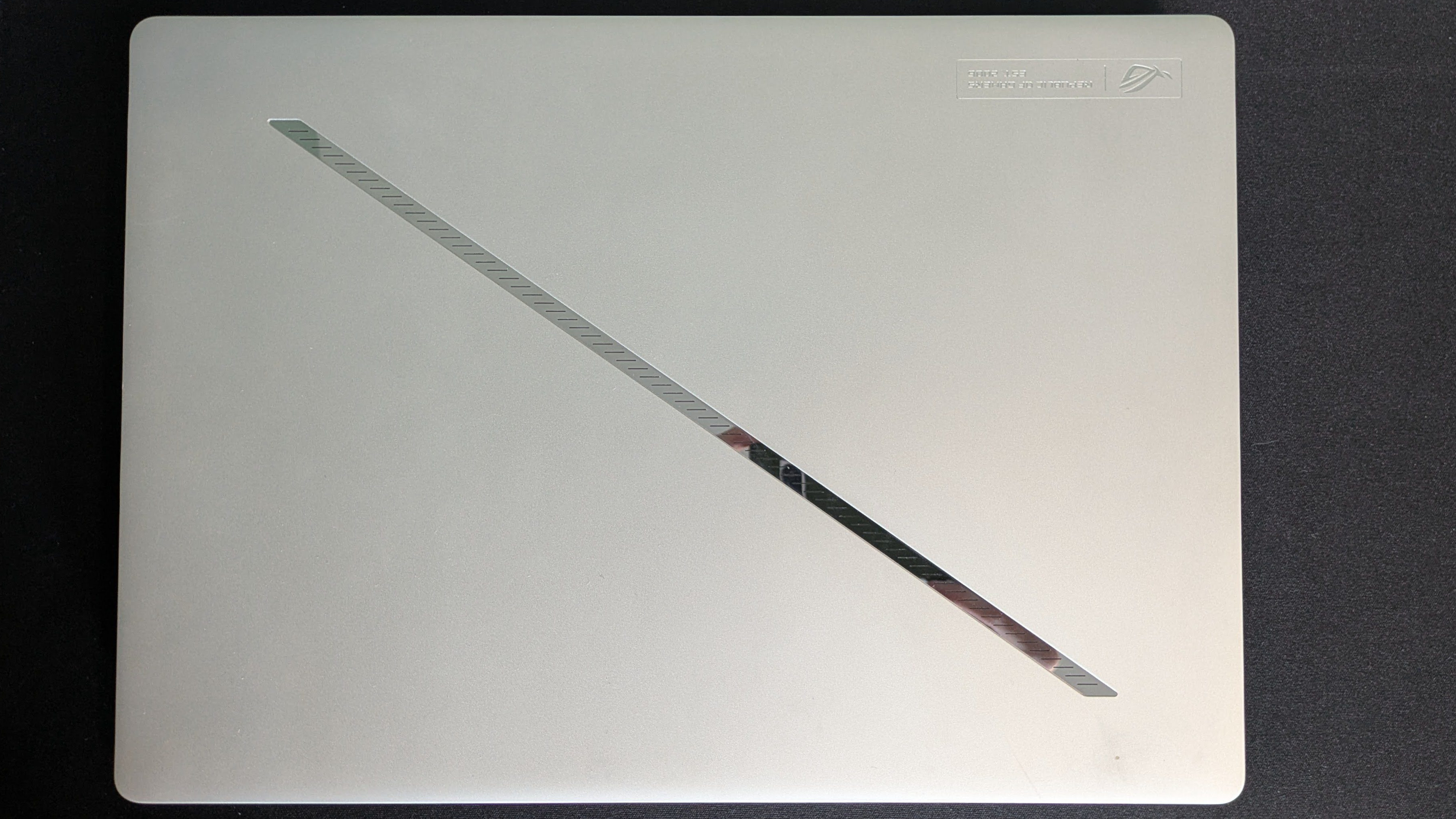 Bird&#039;s eye view of closed lid on Asus ROG Zephyrus G14 (2025) on a black background
