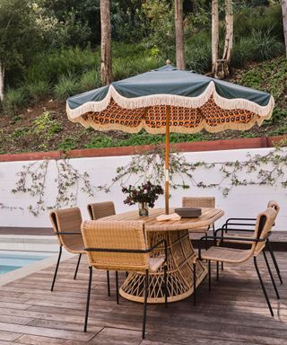 poolside patio with parasol and rattan furniture