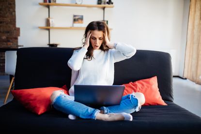 Infobesity: Shocked woman looking at laptop computer screen at home unpleasantly surprised by email notification message reading bad news online about debt, unexp