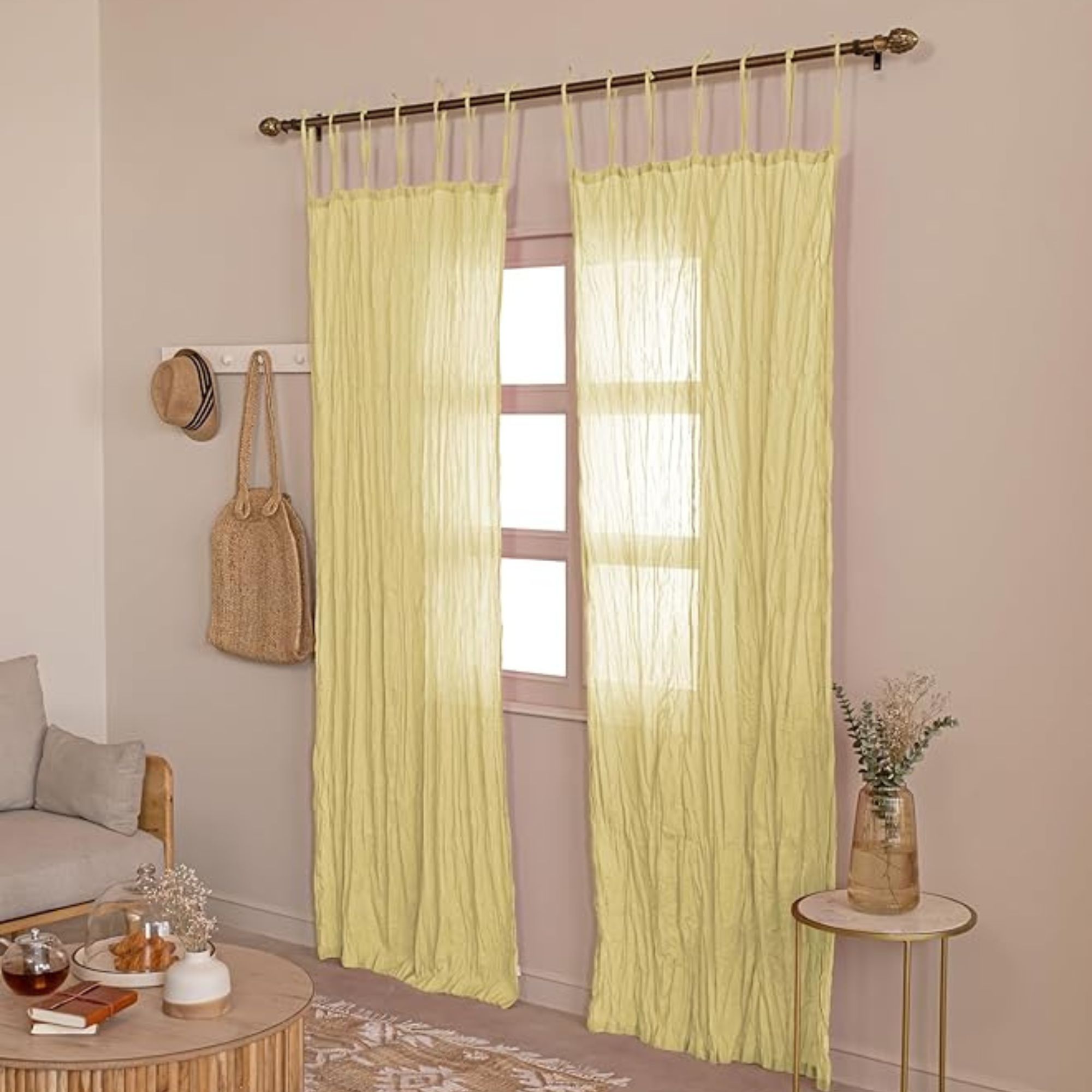 Crinkle semi-sheer butter yellow net curtains in taupe living room with wicker and other natural accents