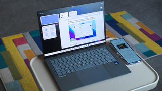 ASUS Googlebook 14 open with widgets and apps open alongside a Samsung Galaxy Z Flip 7