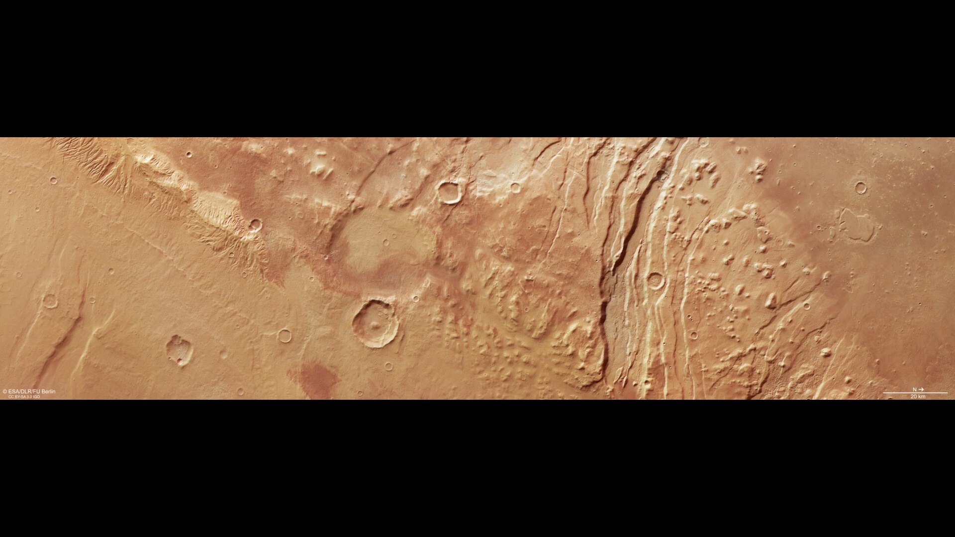 A series of streaks and dots show the dynamic landscape on the reddish brownish surface of Mars