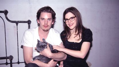 American actor Ethan Hawke, holding a cat, and musician Lisa Loeb on the set of the music video "Stay," March 28, 1994. The song appeared on the soundtrack of the film "Reality Bites."