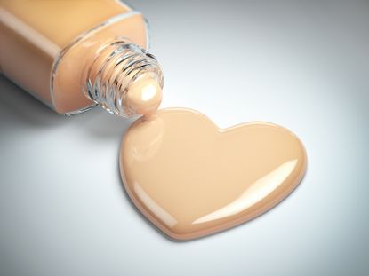 Liquid makeup foundation cream in form of the heart symbol and glass bottle