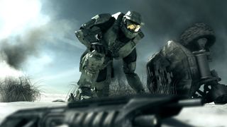 best Halo games: Master Chief inspecting a weapon on teh ground