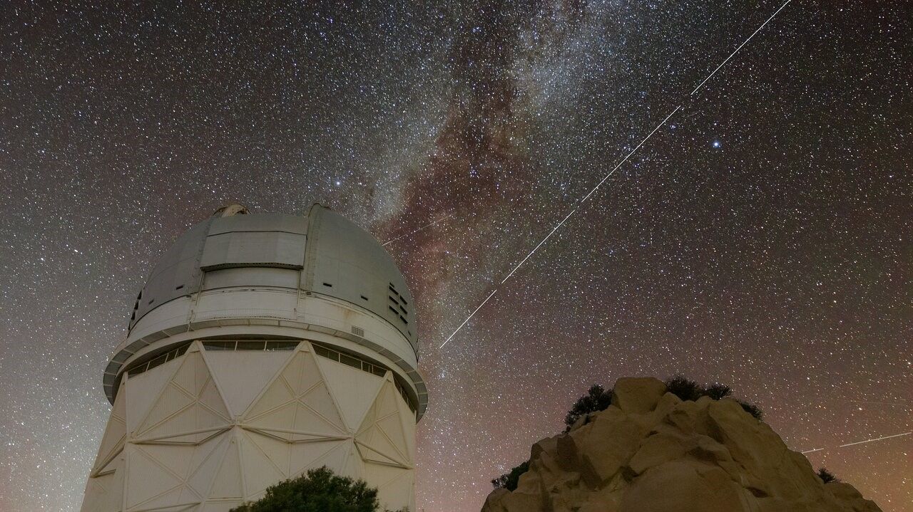 Trails in the night sky left by BlueWalker 3 are juxtaposed against the Nicholas U. Mayall 4-meter Telescope at Kitt Peak National Observatory in Arizona