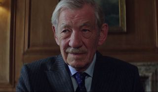The Good Liar Ian McKellen smiling in his office during a transaction