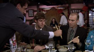 Michael eating food off a stranger's plate with chopsticks in The Office