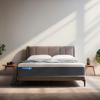 A render of the Simba Hybrid Pro mattress on a grey upholstered bed in a bedroom