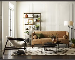 A tan leather sofa with a contemporary accent chair in a classically styled living room