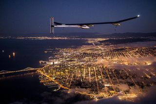 On a test flight, the Solar Impulse aircraft flies at night over San Francisco, Calif.