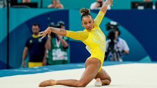 Rebeca Andrade, a yellow leotard, performing on the Floor Exercise at the 2024 Olympic Games.