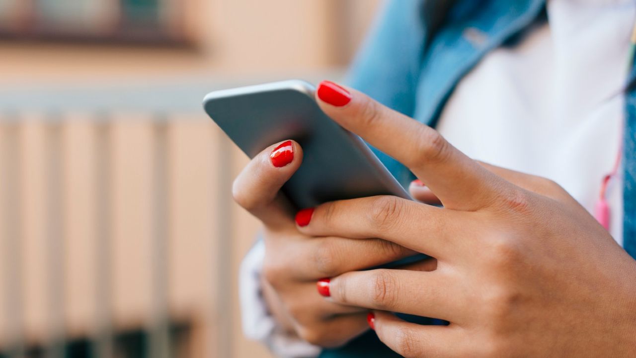 woman&#039;s hands holding a phone 