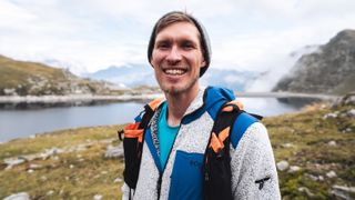 Smiling man wearing a fleece jacket in the mountains