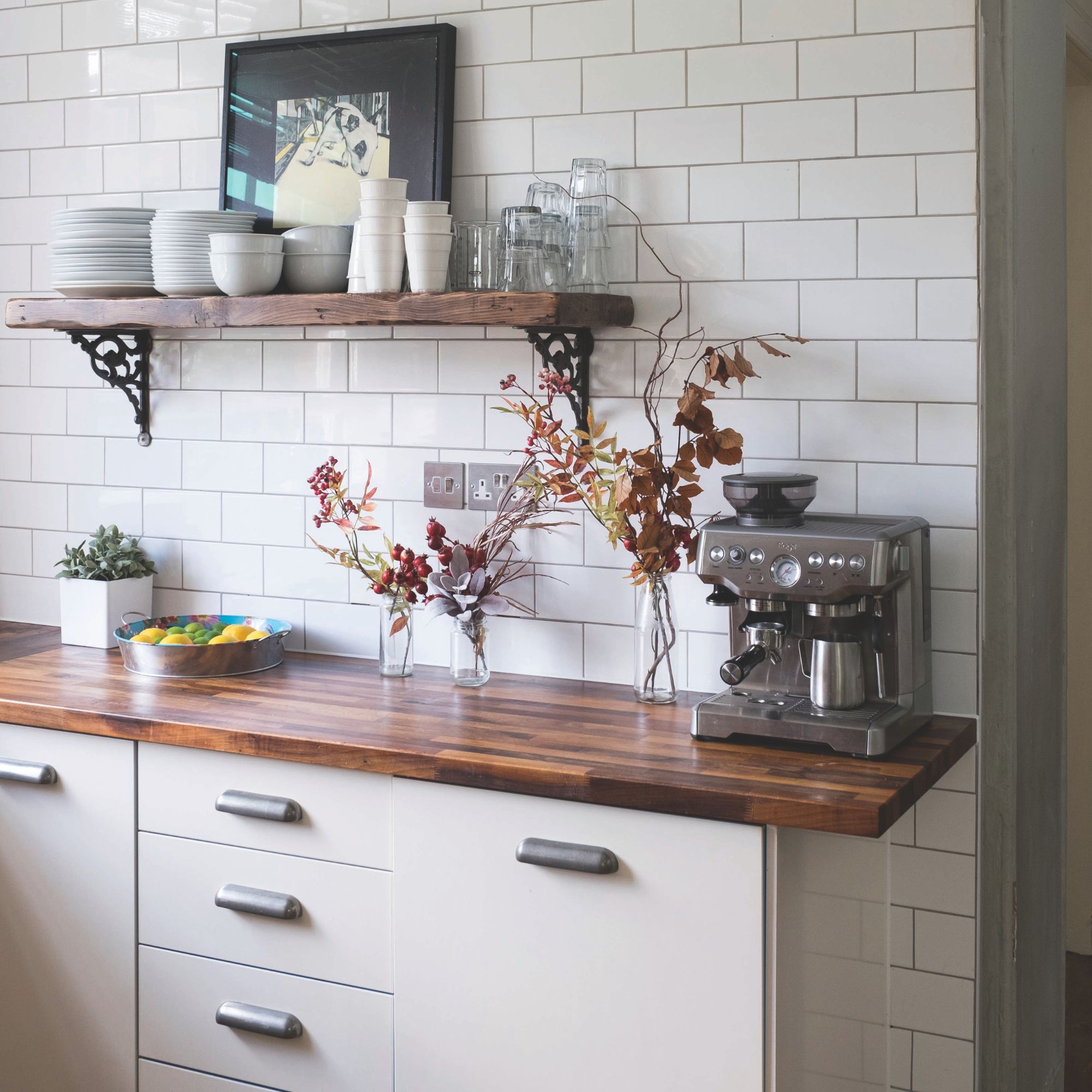 KItchen with white metro tiles, a wooden worktop and cream cabinets