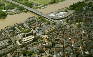 Daytime, aerial view of Cultural Centre Rozet, Arnhem, surrounding city landscape, buildings, river, bridge roads, grass, trees, cars, houses