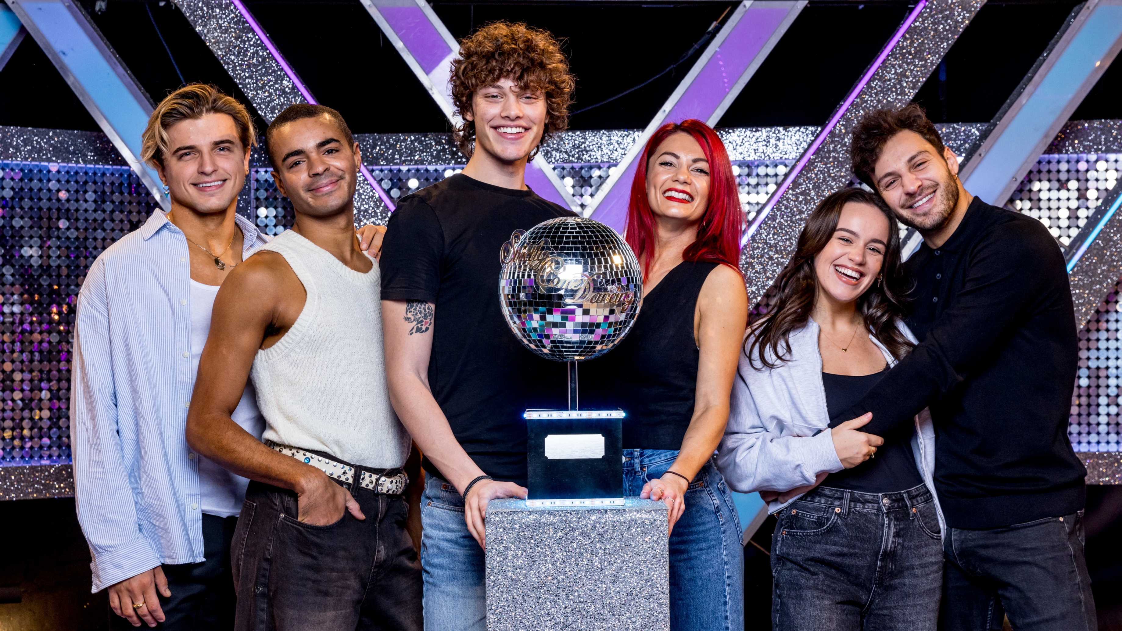 Strictly Come Dancing 2023 finalists Nikita Kuzmin, Layton Williams, Bobby Brazier, Dianne Buswell, Ellie Leach & Vito Coppola all standing around the glitterball trophy