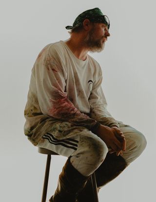 portrait of artist Sterling Ruby sat on chair