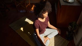 Woman meditating at home on a yoga mat