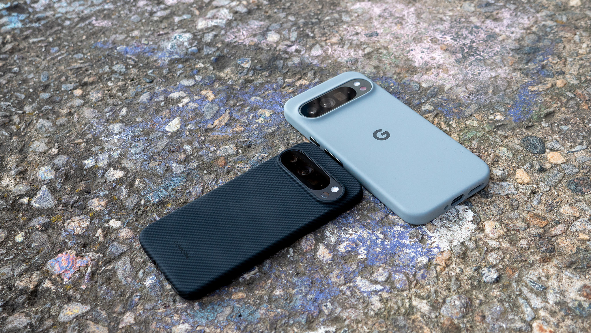 A Google Pixel 9 Pro in a Thinborne aramid fiber case and a Google Pixel 9 Pro XL in an official Google case