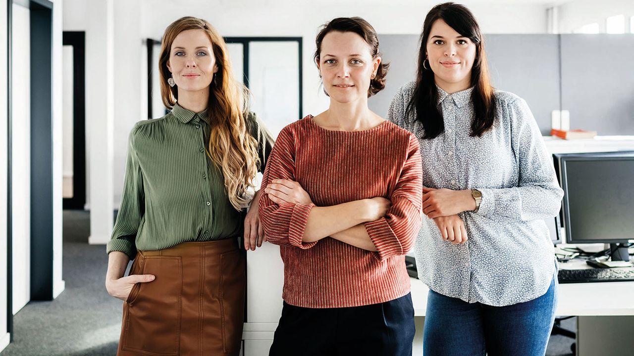 Three women standing in an office 