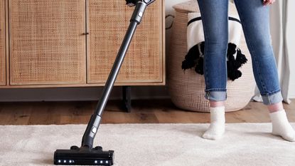 Image of Levoit VortexIQ40 Cordless Stick Vacuum in promotional image being used on carpet 