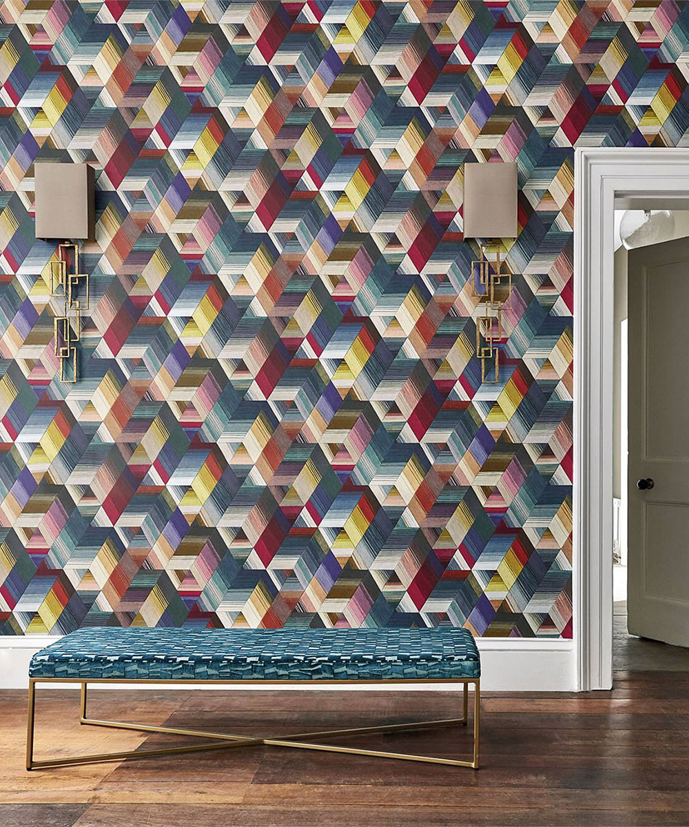 Multicolored graphic wallpaper in front of a blue upholstered bench seat