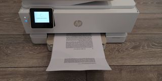 Image shows the HP Envy Inspire in the process of printing pages of text.