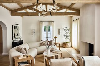 Open neutral lounge with cozy furnishings, curved couches and exposed wooden beams, exuding warm minimalism trend