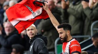 Andros Townsend holds up a Tom Lockyer shirt after his goal against Newcastle in December 2023, following the defender's cardiac arrest on the pitch against Bournemouth.