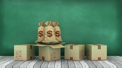 Cardboard boxes with dollar money sacks against a green chalkboard background 