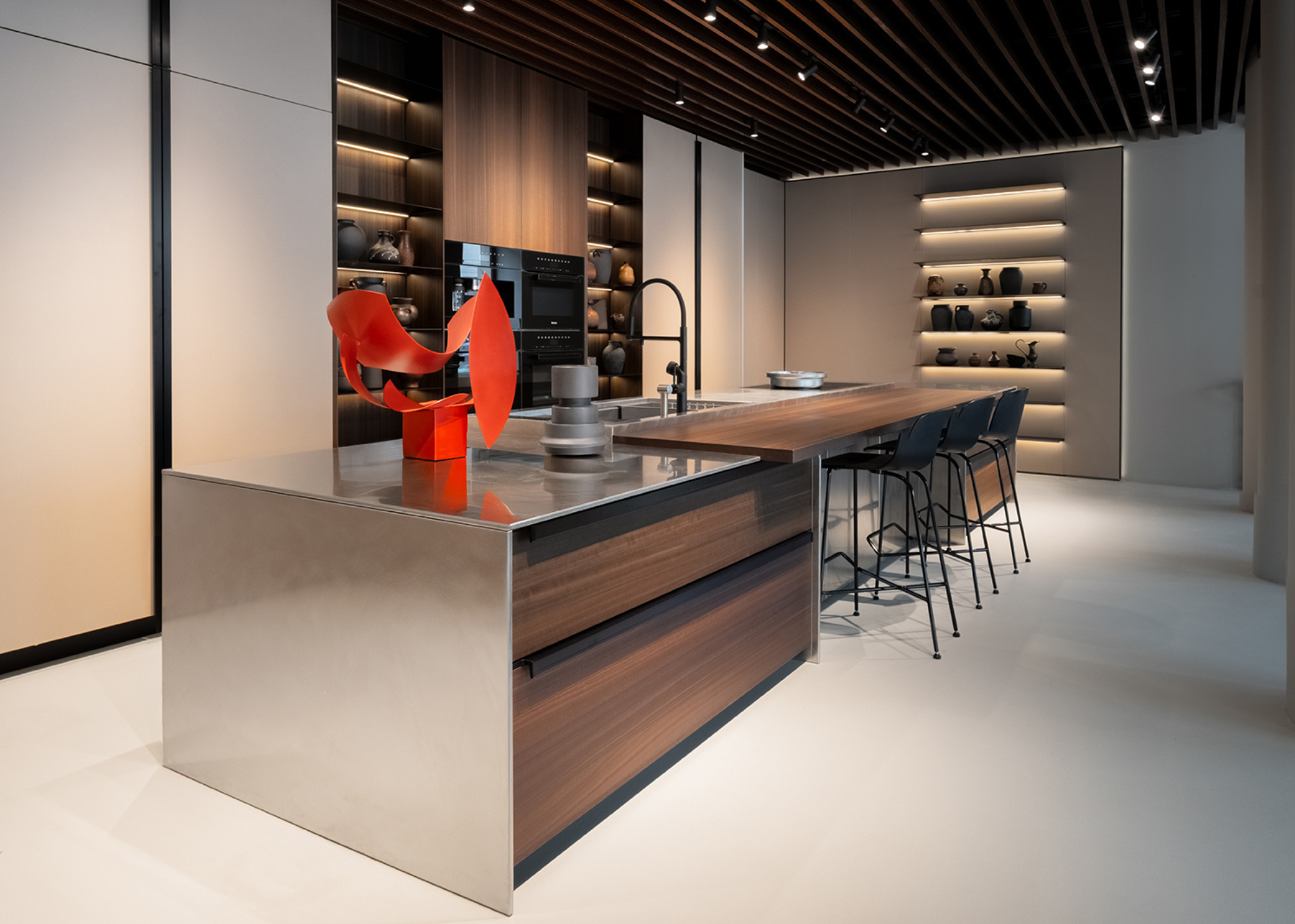 A kitchen showroom with an island and a shelving system on display