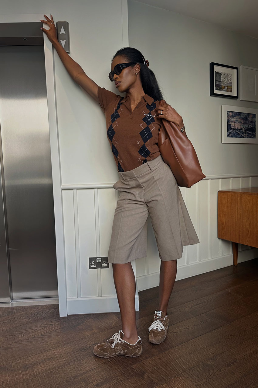 a woman wearing a brown polo shirt, brown long shorts, and brown sneakers