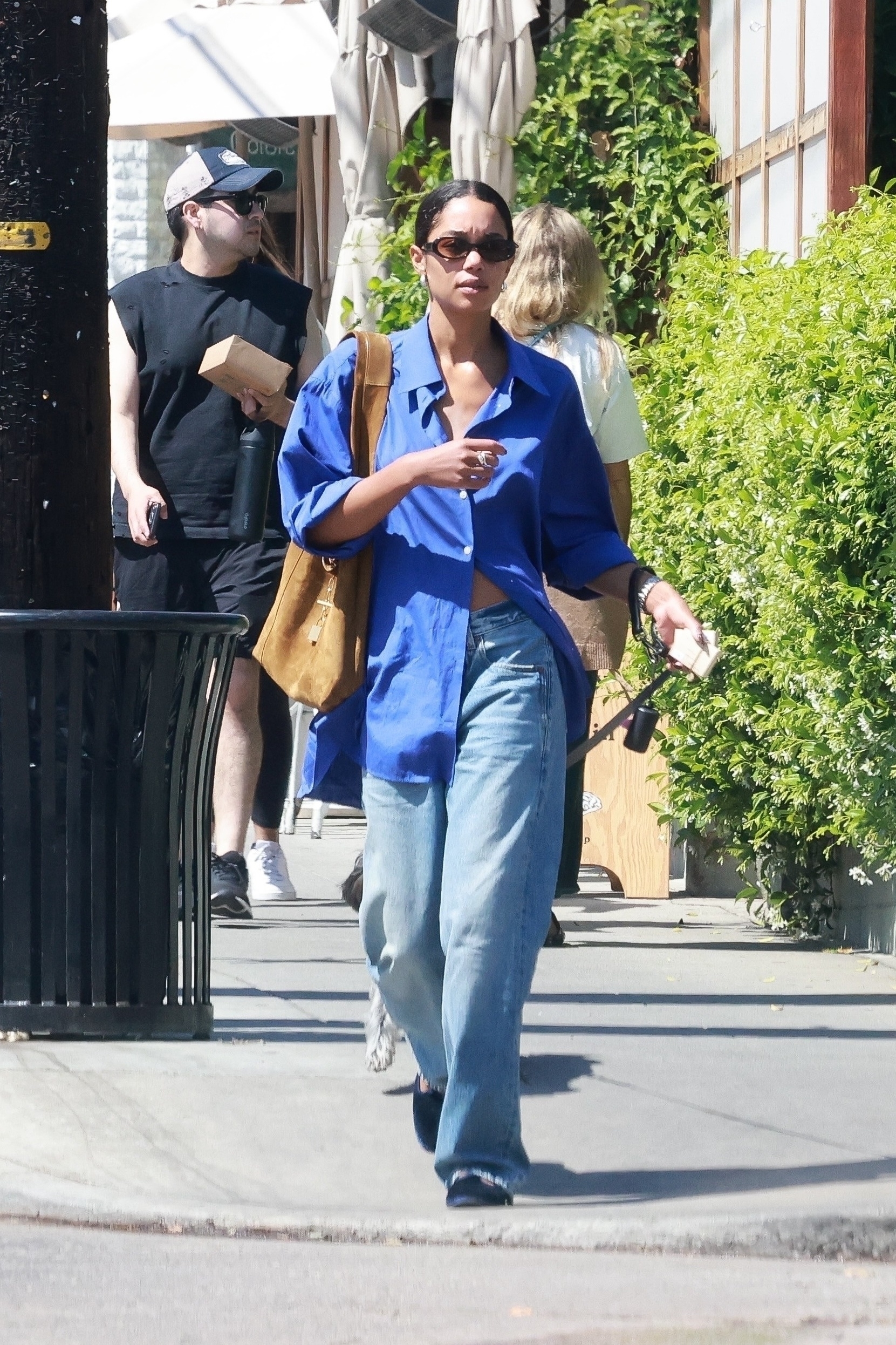 Laura Harrier wears an oversized shirt with baggy jeans.
