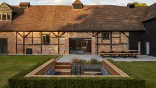 exterior of barn conversion with sunken garden seating area